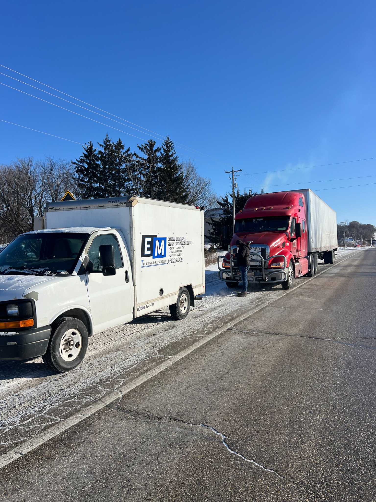 EM Trucking and Repairs mobile roadside repair truck assisting a semi in winter